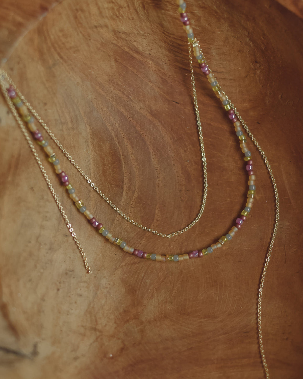 handmade beaded necklace layered with dainty gold-plated chain