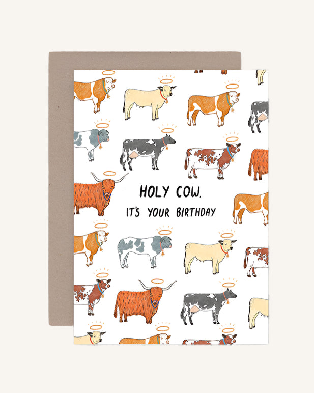 A greeting card with a pattern of cartoon cows and the text 'HOLY COW IT'S YOUR BIRTHDAY' across the middle. It comes with a brown envelope.