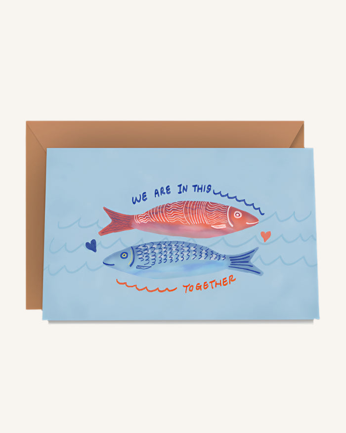 Greeting card with two fish illustrations and text on a blue background, accompanied by a brown envelope.