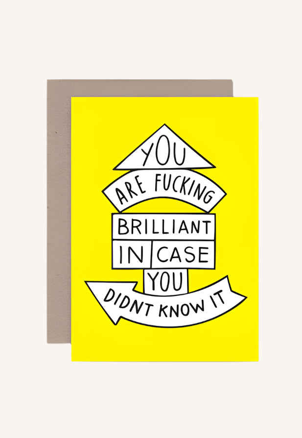 A yellow greeting card with black text stating 'YOU ARE BRILLIANT IN CASE YOU DIDN'T KNOW IT' with a brown envelope.
